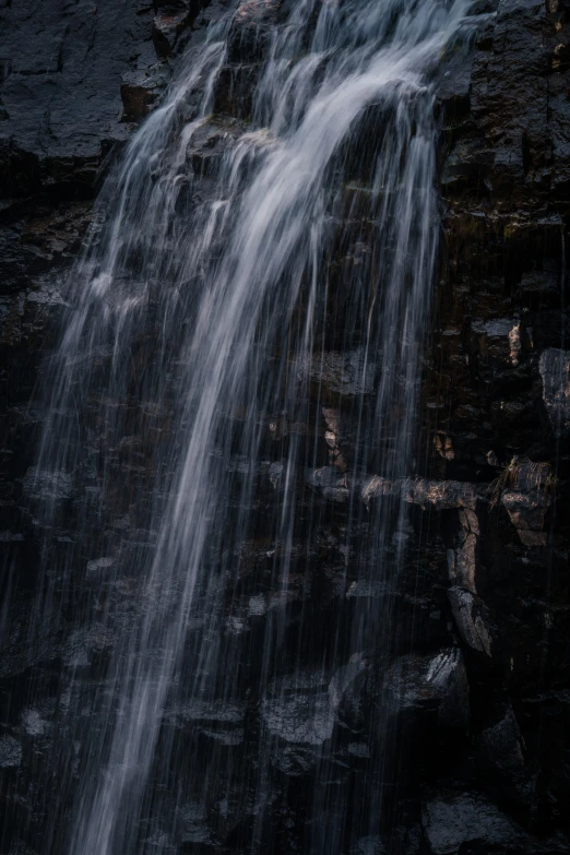 a waterfall in the middle of a rocky area, an album cover, unsplash contest winner, medium format. soft light, detail shot, waterfall walls, dark