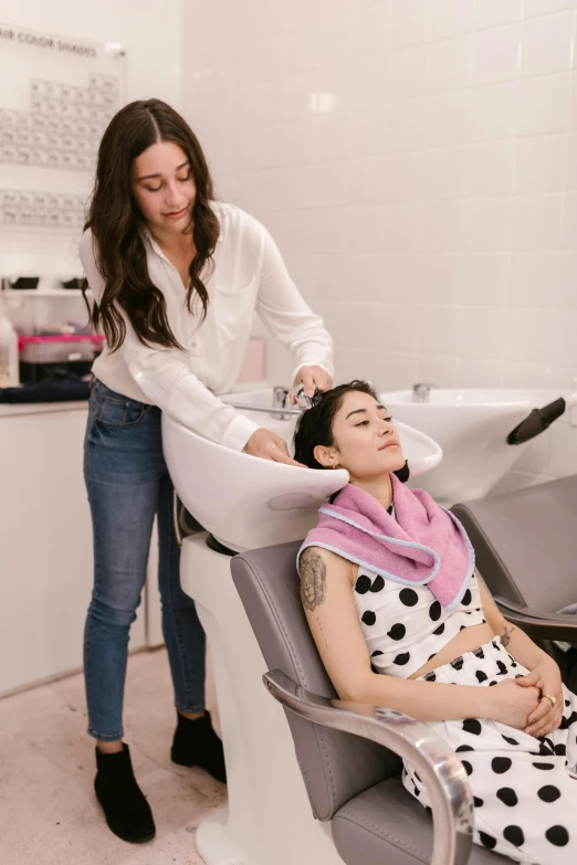 a woman getting her hair done in a salon, by Nicolette Macnamara, milk - bath effect, thumbnail, grey, full-body