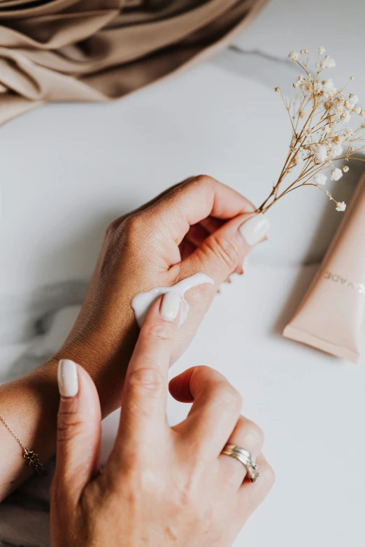 a close up of a person holding a flower, skincare, cream and white color scheme, inspect in inventory image, silicone skin