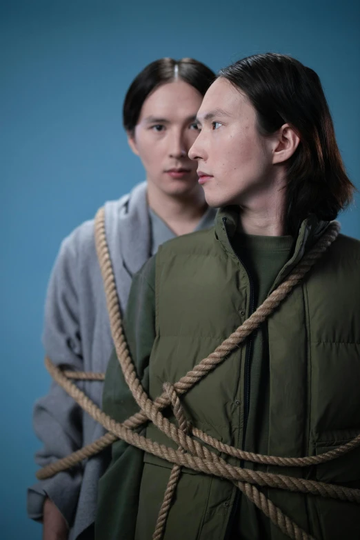 a couple of women standing next to each other, an album cover, inspired by Fei Danxu, unsplash, conceptual art, rope bondage, two young men, wearing a turtleneck and jacket, actor