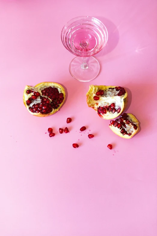 a couple of pomegranates sitting on top of a pink table, by Lucette Barker, pexels, toast, bubbly, persona, do