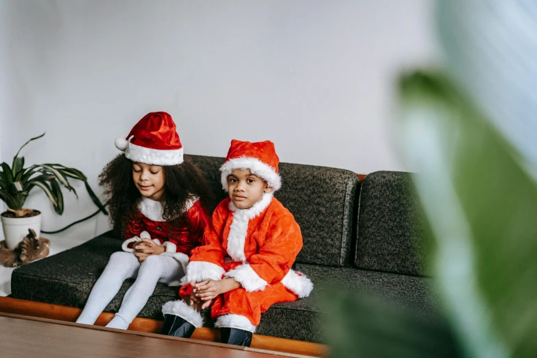 a couple of kids sitting on top of a couch, pexels, incoherents, wearing festive clothing, avatar image, santa clause, young girls