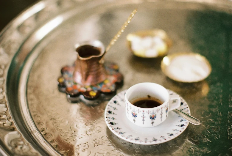 a silver tray topped with a coffee cup and saucer, trending on unsplash, arabesque, turkey, taken with kodak portra, square, brown