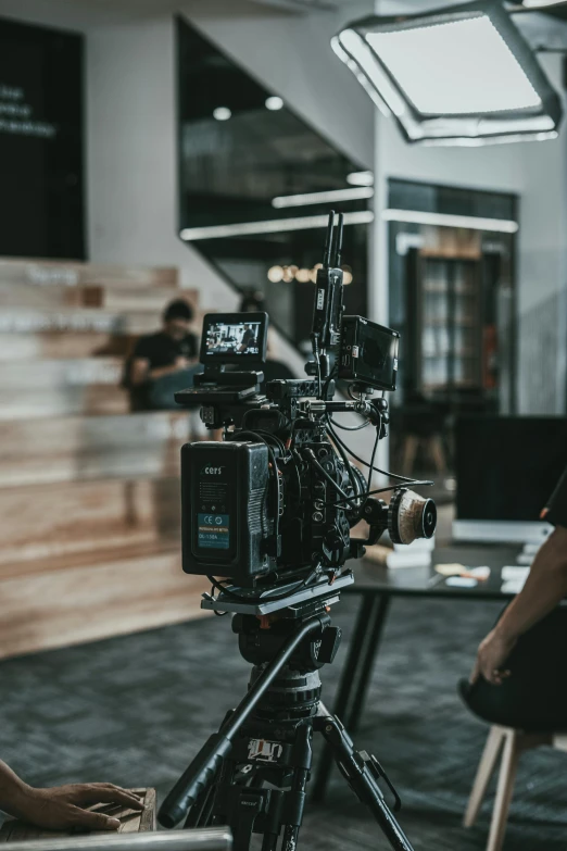 a man sitting in front of a camera on a tripod, tv production, unsplash 4k, movie cover, looking back at the camera