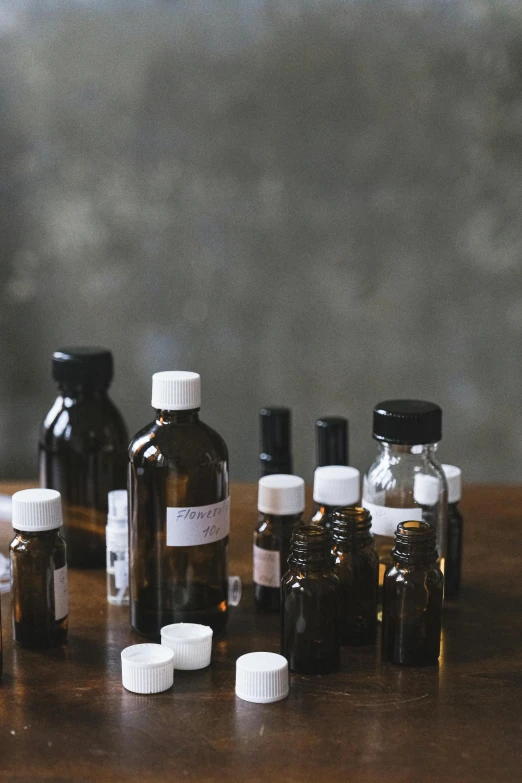 a group of bottles sitting on top of a wooden table, a portrait, unsplash, medical lab, studio medium format photograph, brown, small