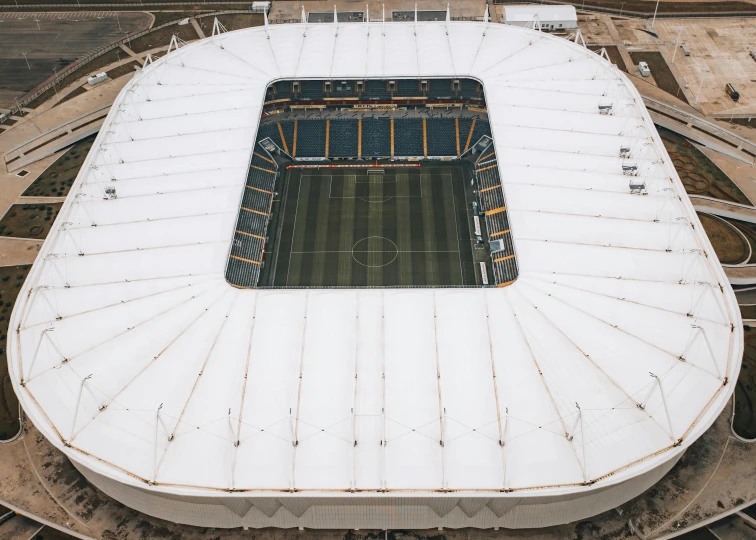 an aerial view of an empty soccer stadium, by Carey Morris, unsplash contest winner, conceptual art, rounded roof, hull, cardboard, huge gargantuan scale