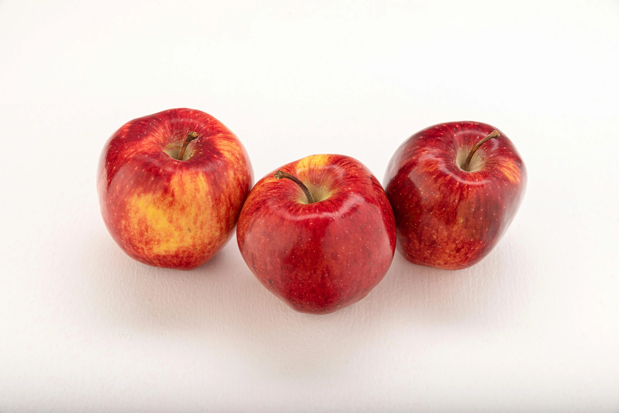 three apples sitting next to each other on a white surface, 6 pack, mangeta smoke red light, full colour, 3 mm