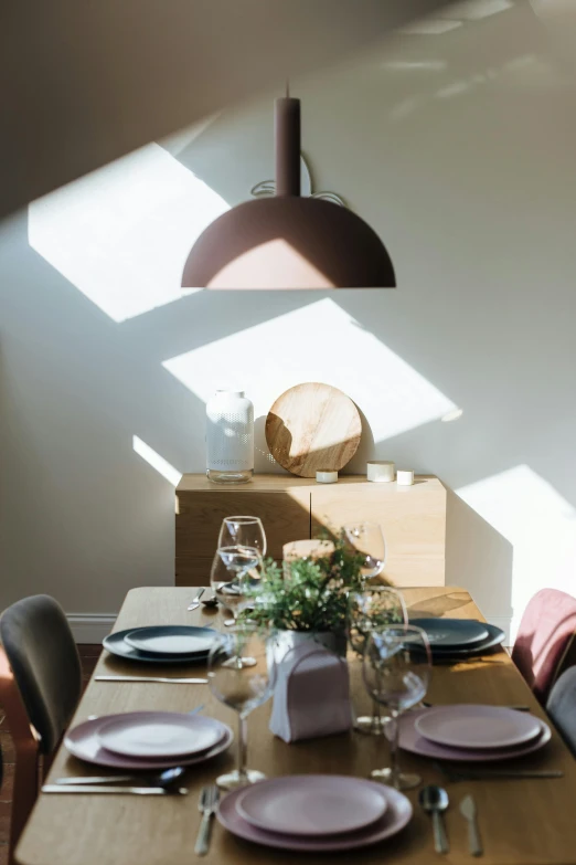 a wooden table topped with plates and glasses, inspired by Constantin Hansen, unsplash, light and space, sharp sunray lighting, soft shade, uplit, dining room