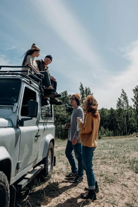 a group of people standing on top of a vehicle, pexels contest winner, renaissance, land rover defender, profile pic, picnic, looking left