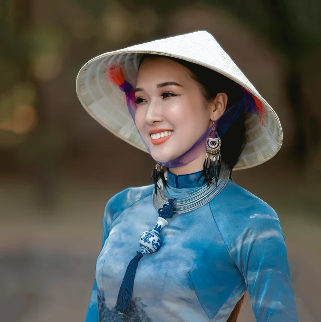 a close up of a person wearing a hat, inspired by Jin Nong, pexels contest winner, cloisonnism, ao dai, portrait image, tourist photo, costume with blue accents