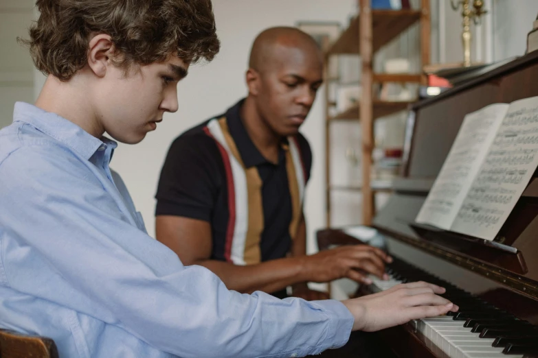 two young men are playing the piano together, by Everett Warner, pexels contest winner, flat colour, looking across the shoulder, studious, anthony pafford