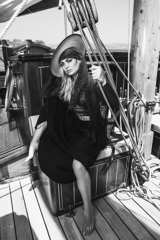 a black and white photo of a woman on a boat, inspired by August Sander, renaissance, witch clothes, on a super yacht, oldwest, in a black chiffon layered robe