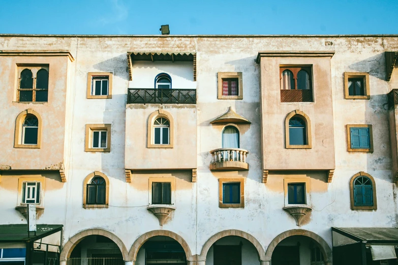 a very tall building with lots of windows, inspired by Ricardo Bofill, pexels contest winner, renaissance, conversano, white houses, traditional corsican, rounded roof