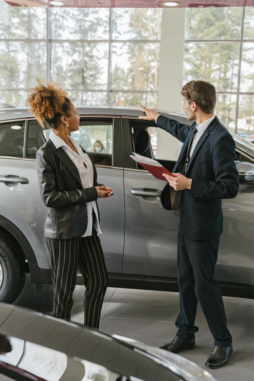 a man and woman looking at a car in a dealers showroom, pexels contest winner, renaissance, woman in business suit, mid body, multi chromatic, thumbnail