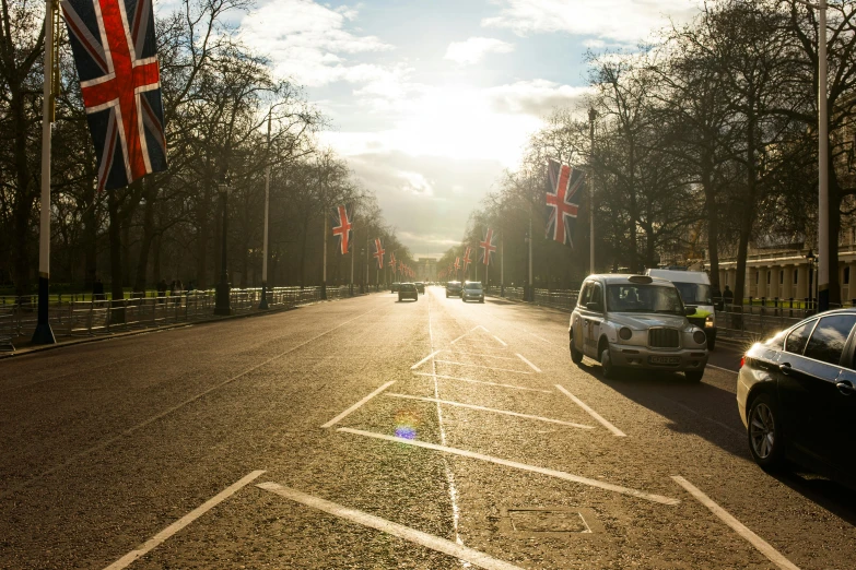 a street filled with lots of cars driving down it, a picture, by Lee Loughridge, unsplash, union jack, sunlight glistening, the white house, gopro photo