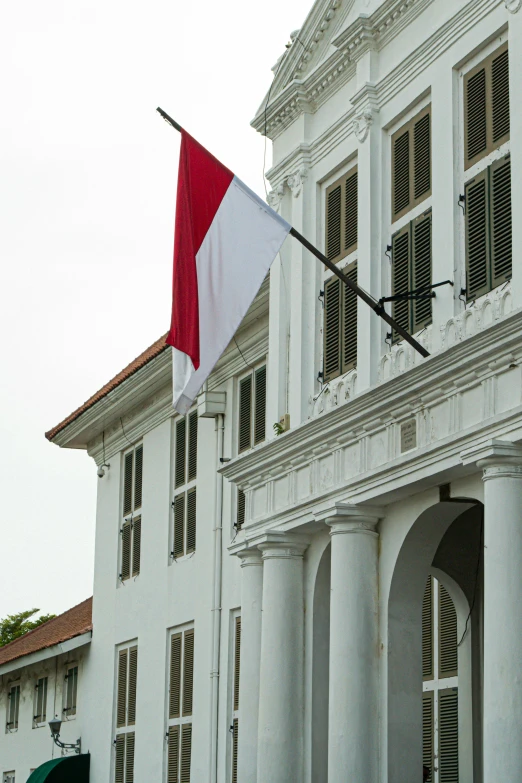 a large white building with a red and white flag, inspired by Nil Gleyen, south jakarta, colonial, exterior, holiday