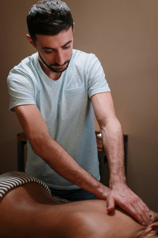 a man getting a back massage at a spa, a colorized photo, by Nina Hamnett, sitting with wrists together, congas, hyperrealistic ”, grain”