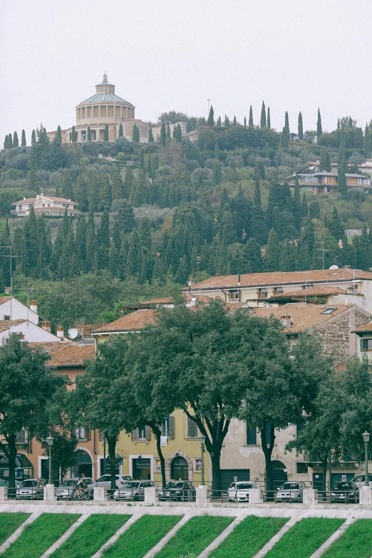a group of people riding horses across a lush green field, inspired by Serafino De Tivoli, trending on unsplash, renaissance, city buildings on top of trees, italian mediterranean city, dome, square