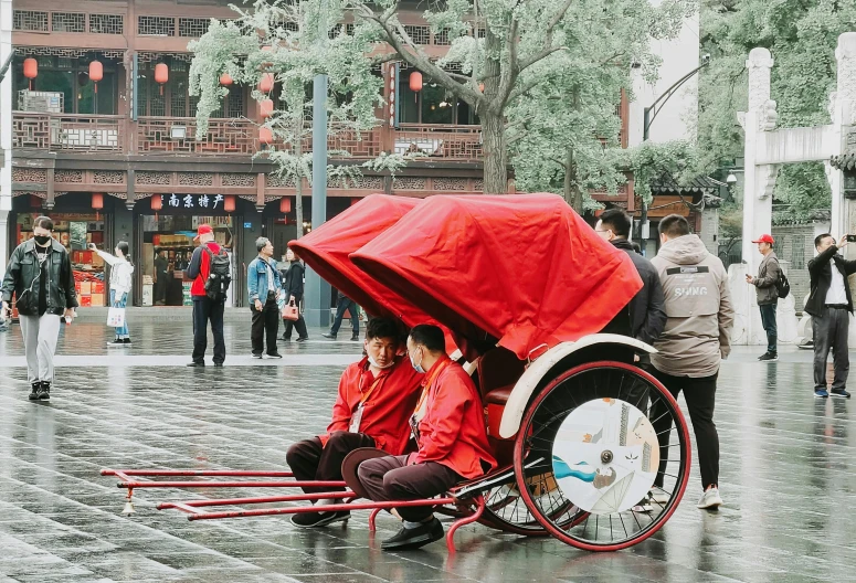 a couple of people sitting under a red umbrella, by Shang Xi, pexels contest winner, gutai group, carriage, city morning, fully clothed in red robes, rectangle