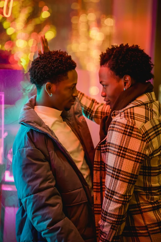 two people standing next to each other in front of a neon sign, by Cosmo Alexander, trending on pexels, two men hugging, 2 1 savage, noire moody scene, [ theatrical ]