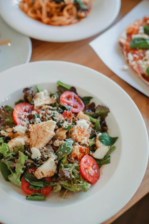 a wooden table topped with plates of food, salad, thumbnail, square, pizza on a table