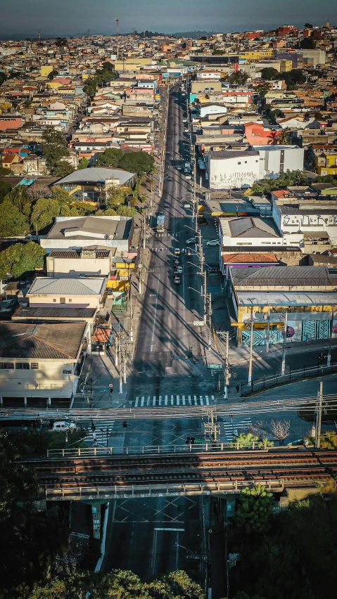 an aerial view of a city with lots of buildings, an album cover, by Alejandro Obregón, unsplash, realism, street tram, brazil, overpass, suburb