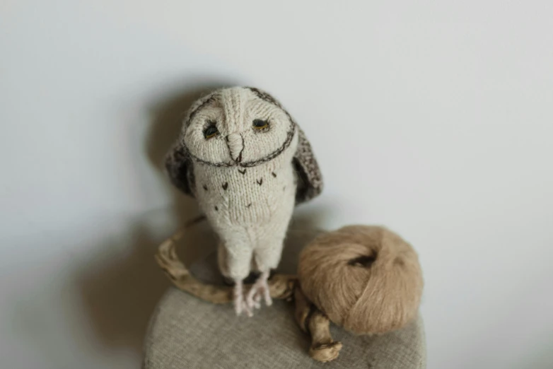 a stuffed owl sitting on top of a chair next to a ball of yarn, a portrait, by Sylvia Wishart, unsplash, full body close-up shot, small in size, with highly detailed, hand