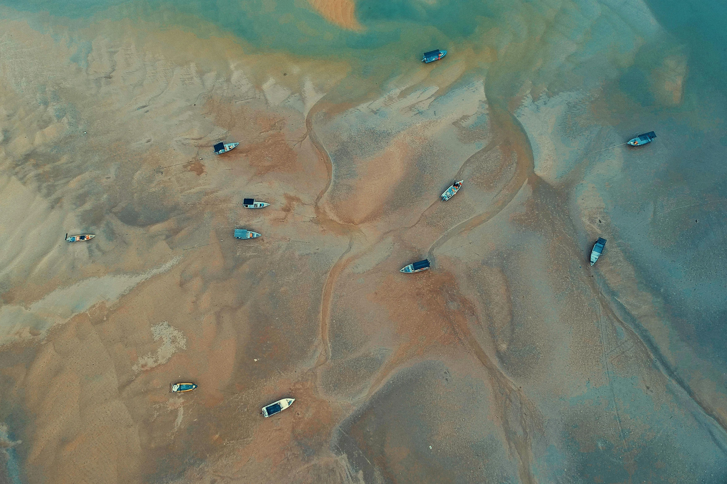 a group of boats sitting on top of a sandy beach, by Adam Marczyński, pexels contest winner, conceptual art, aerial iridecent veins, the normandy landings, thumbnail, mining