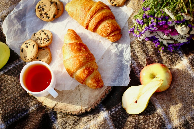 a couple of croissants sitting on top of a table, a still life, trending on pexels, having a picnic, background image, manuka, colorful”