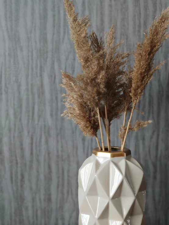 a vase with some plants in it on a table, inspired by Constantin Hansen, trending on unsplash, baroque, dry grass, textured 3 d, beige and gold tones, close-up product photo