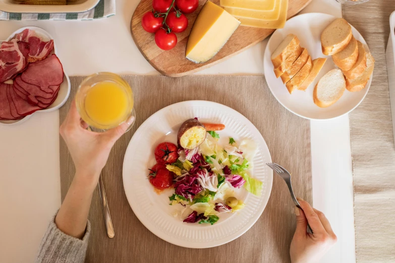 a person sitting at a table with a plate of food, pexels contest winner, yellow aureole, salad, table set for second breakfast, 🦩🪐🐞👩🏻🦳