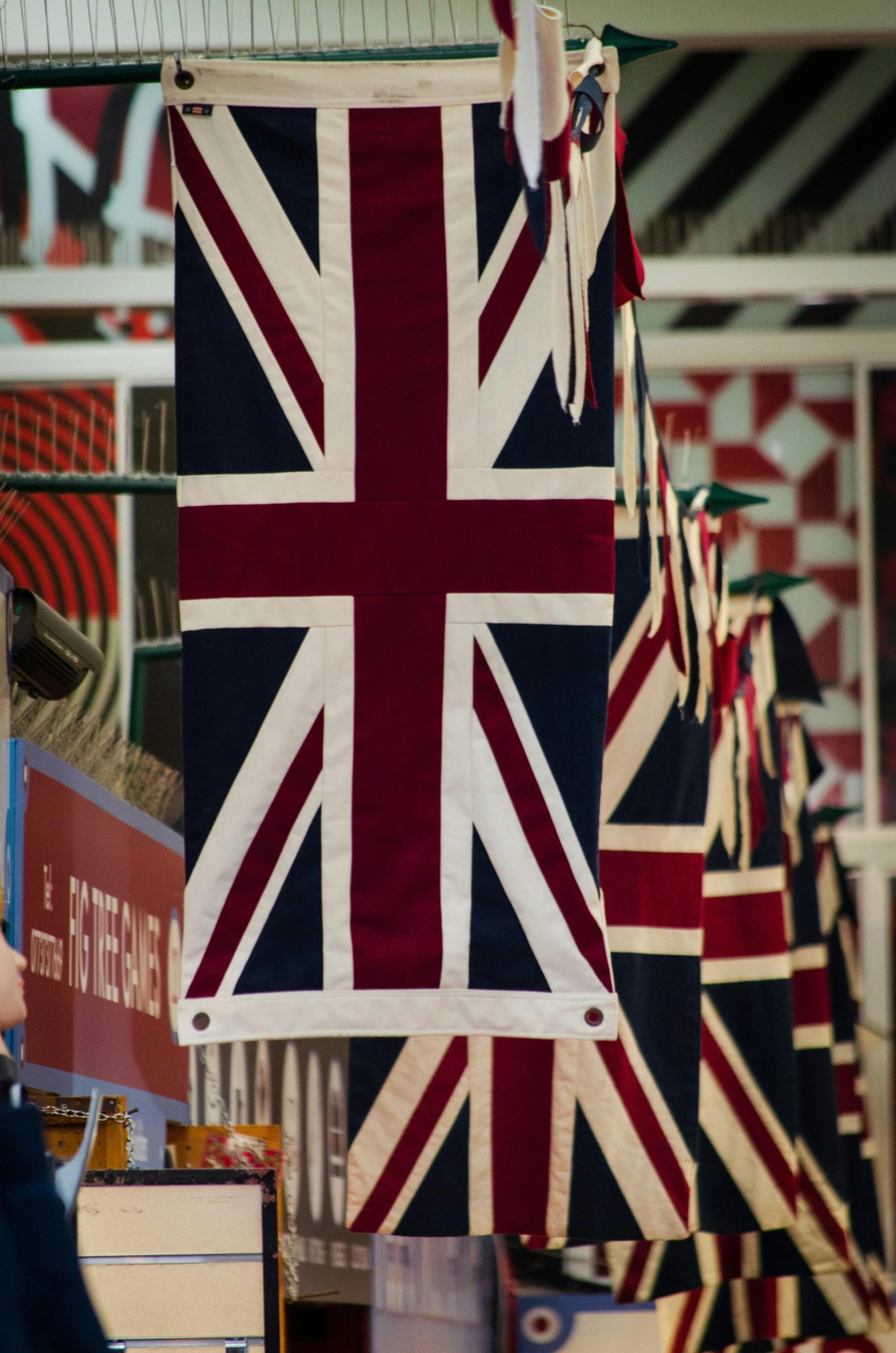 a man standing in front of a display of british flags, by David Simpson, symbolism, red brown and white color scheme, up-close, cloth banners, slide show