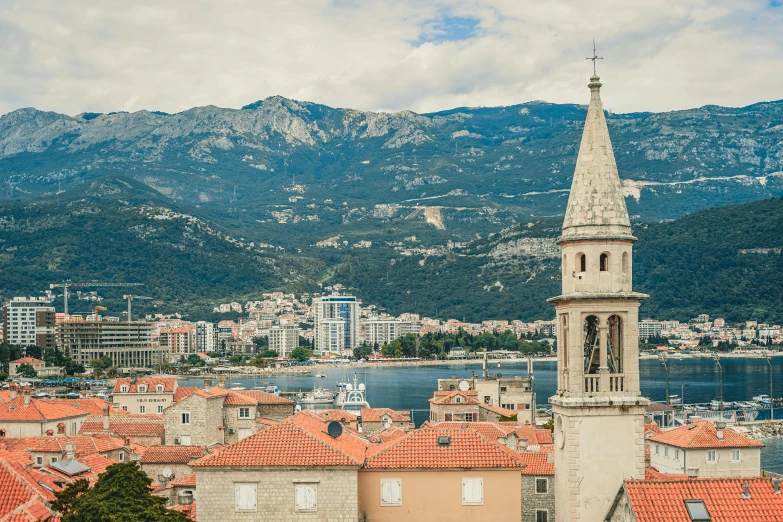 a view of a town with mountains in the background, by Emma Andijewska, pexels contest winner, baroque, split near the left, thumbnail, square, brown