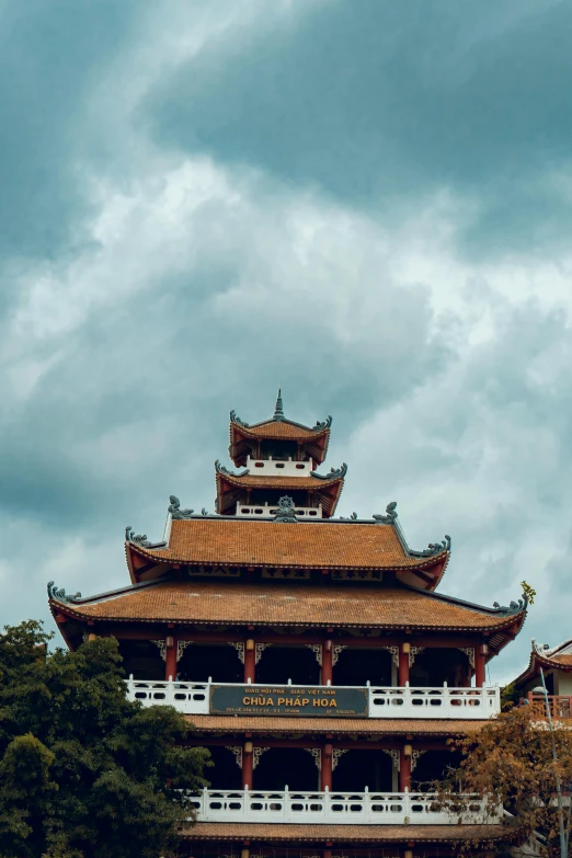 a tall building sitting on top of a lush green field, inspired by Hu Zao, trending on unsplash, cloisonnism, vietnamese temple scene, red roofs, ominous beautiful mood, square