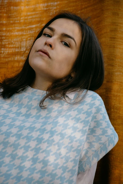 a woman standing in front of a curtain, trending on pexels, hurufiyya, wearing a light blue shirt, poncho, magda torres gurza, portait image