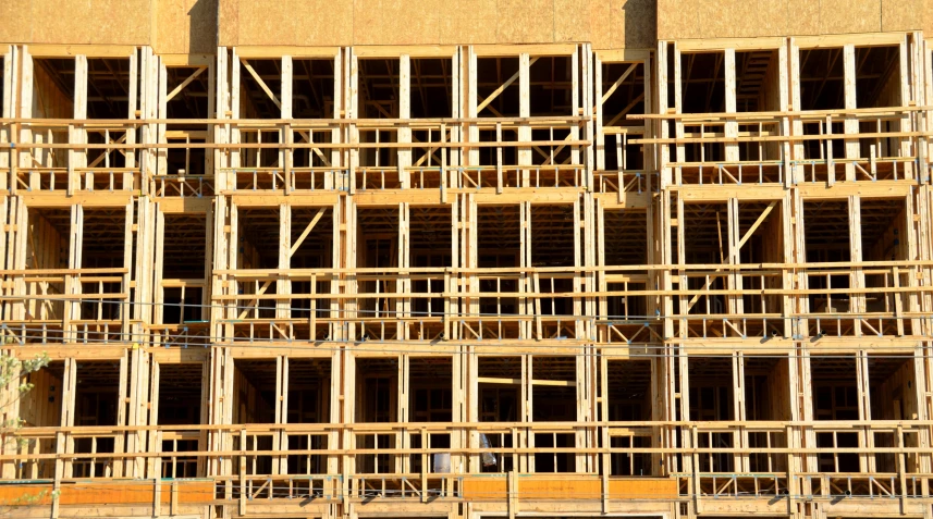 a large building under construction with scaffolding, by Bradley Walker Tomlin, pixabay, wooden crates, in rows, gold, promo image