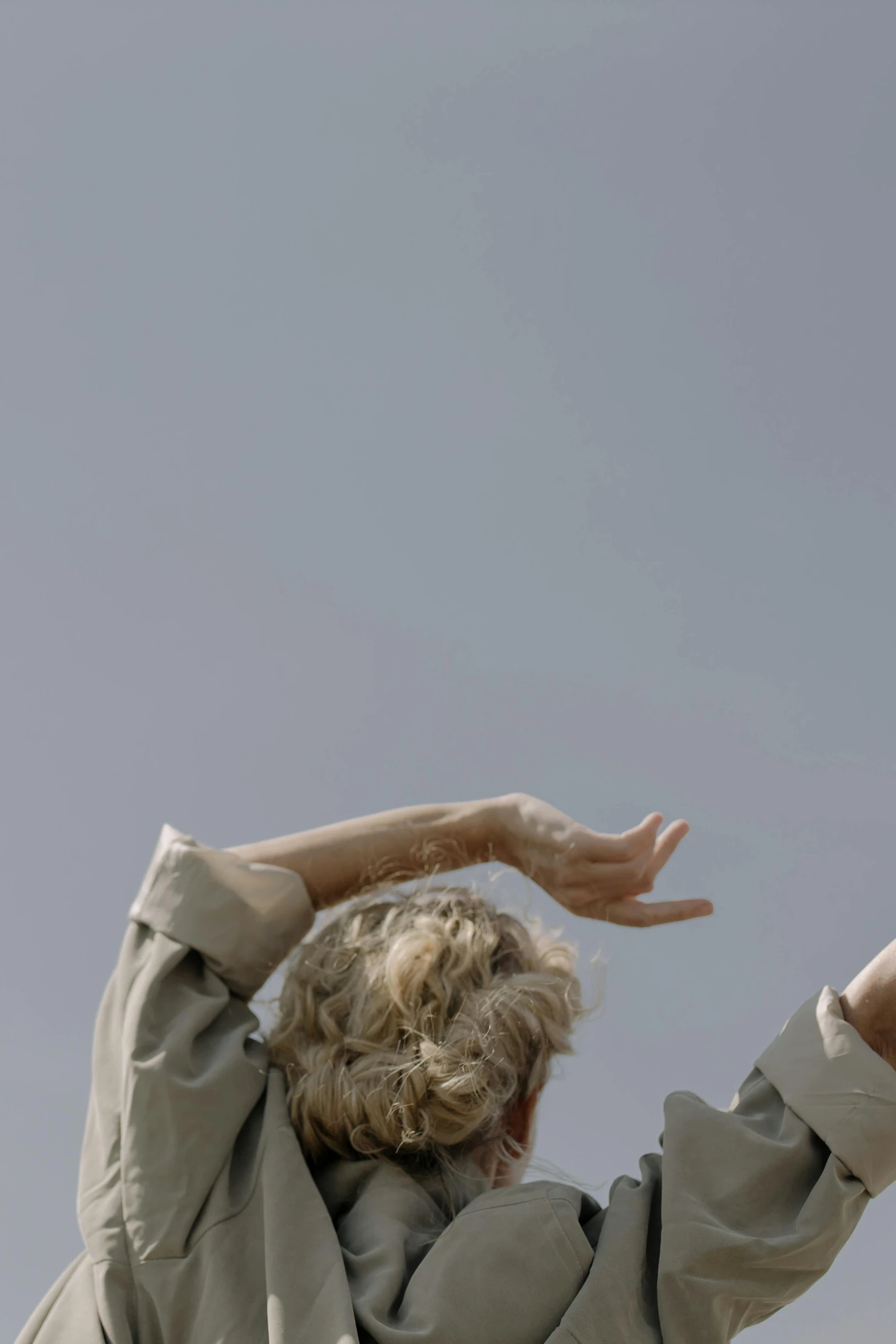 a person that is flying a kite in the sky, by Attila Meszlenyi, hands in her hair. side-view, gray haired, ignant, choreographed