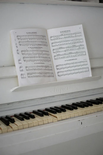 a piano with sheet music sitting on top of it, by David Simpson, pexels, inside white room, 15081959 21121991 01012000 4k, taken in the late 2010s, swedish