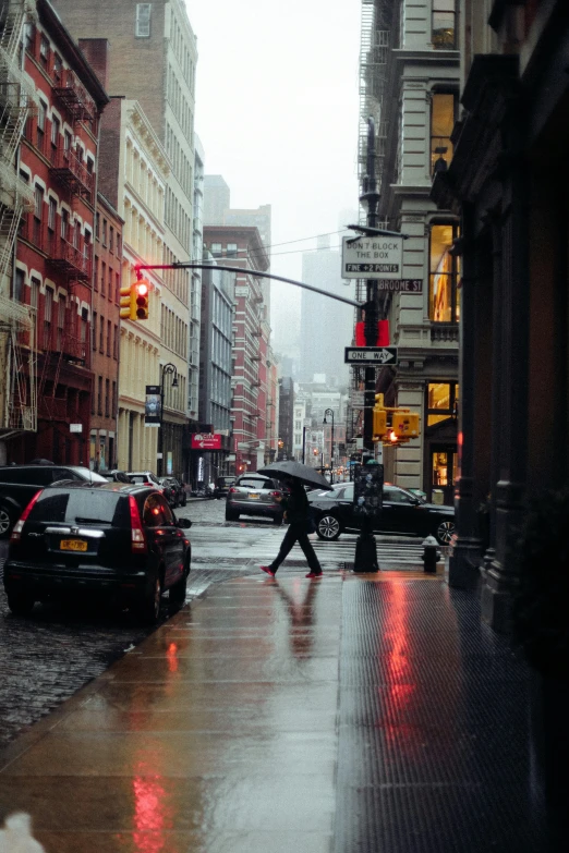 a person with an umbrella crossing the street in the rain, inspired by Elsa Bleda, unsplash contest winner, new york buildings, gif, late afternoon, city streetscape