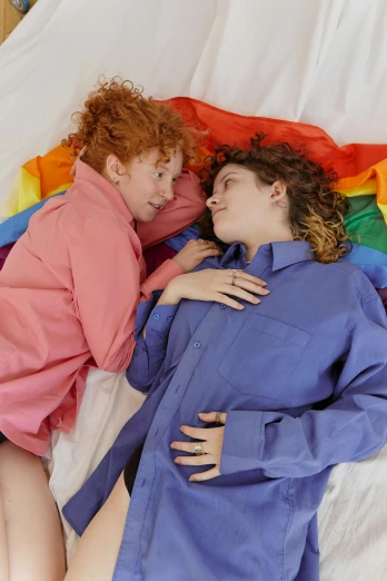 a couple of women laying on top of a bed, trending on reddit, renaissance, rainbow clothes, red haired teen boy, high quality photo, loving embrace