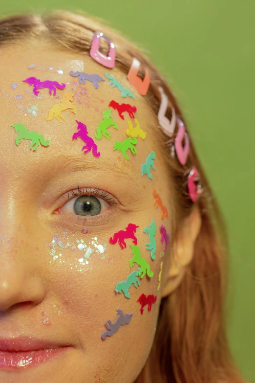 a close up of a person with paint on their face, inspired by Derf, glitter sticker, unicorn, mini model, teenager