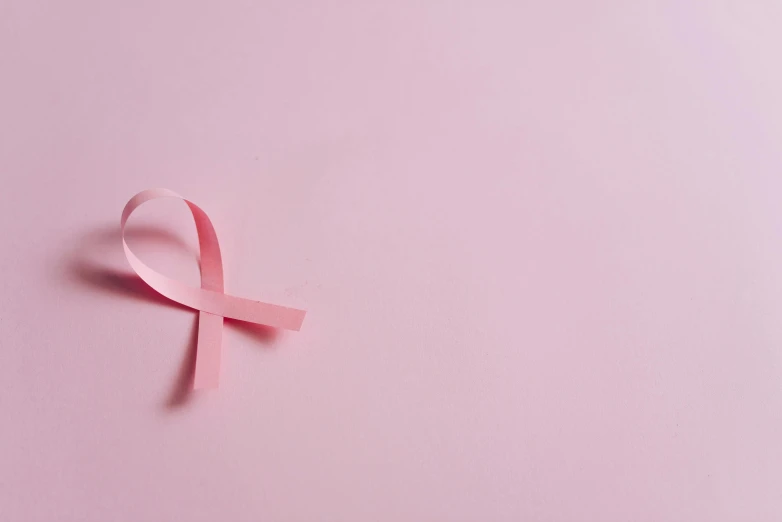 a pink ribbon on a pink background, by Emma Andijewska, pexels, hurufiyya, surgery, background image, instagram post