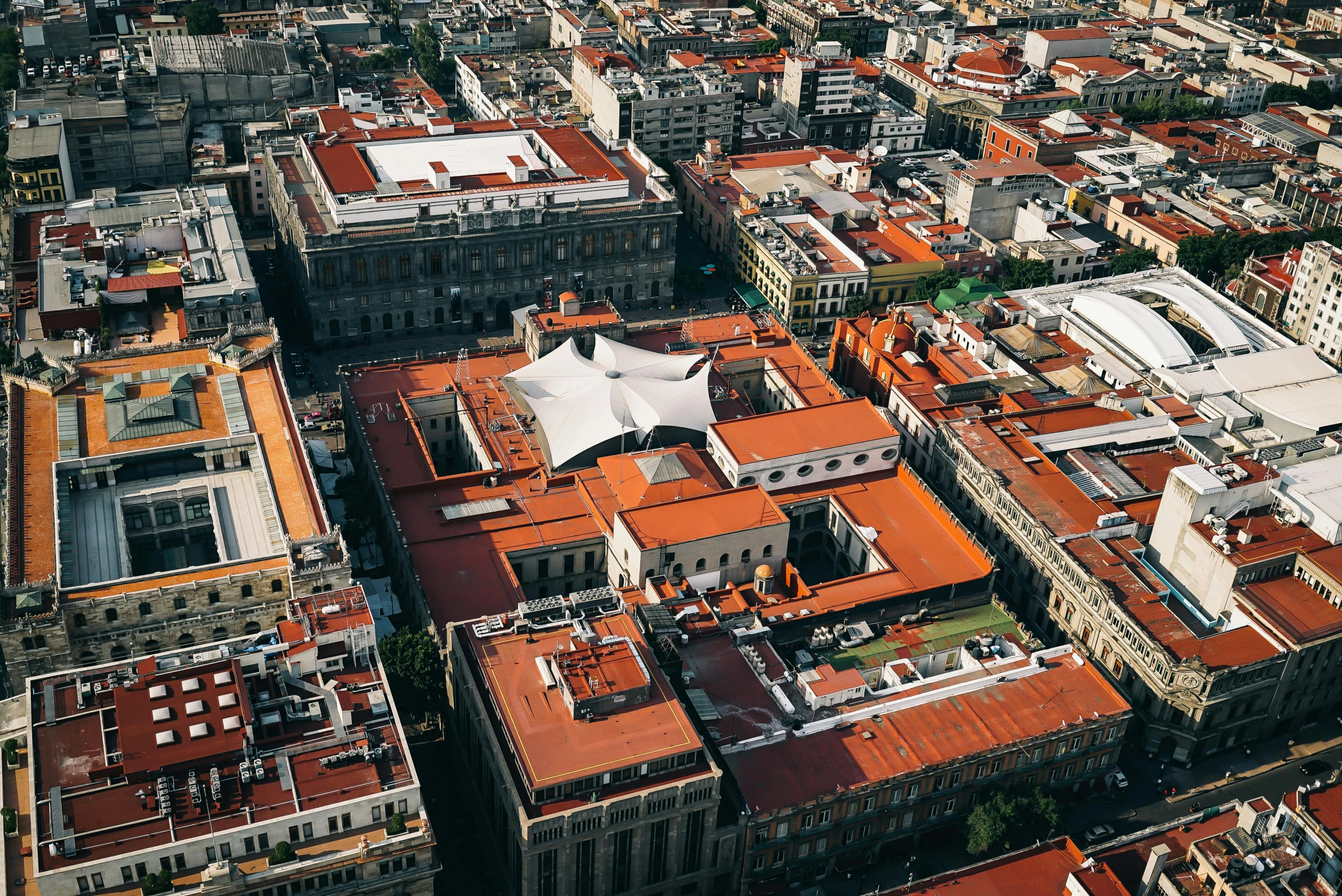 an aerial view of a city with lots of buildings, an album cover, pexels contest winner, quito school, orange roof, mexico city, profile image, demna gvasalia