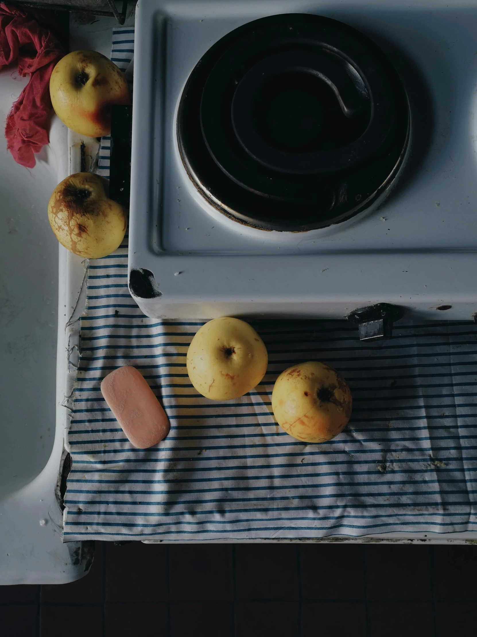 a stove top oven sitting on top of a kitchen counter, a still life, inspired by Elsa Bleda, yellow apples, disgusting food, camera looking down upon, low quality photo