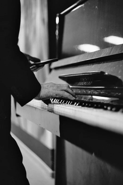 a black and white photo of a person playing a piano, inspired by Richard Wright, unsplash, harlem renaissance, jukebox, evening time, digitally remastered, small details