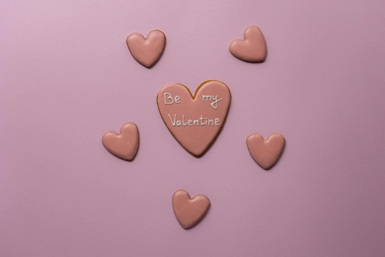 a heart shaped cookie sitting on top of a table, mauve background, background image, shot with sony alpha, gloss