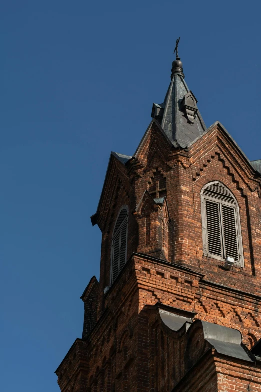 a tall brick building with a clock on it's side, by Jan Tengnagel, unsplash, romanesque, lead - covered spire, high quality photo, rusty metal towers, blue sky