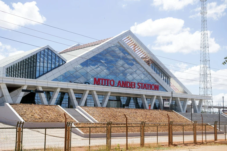 a red fire hydrant sitting in front of a train station, an album cover, inspired by Antonín Chittussi, samburu, mint, architectural photo, huge glass structure