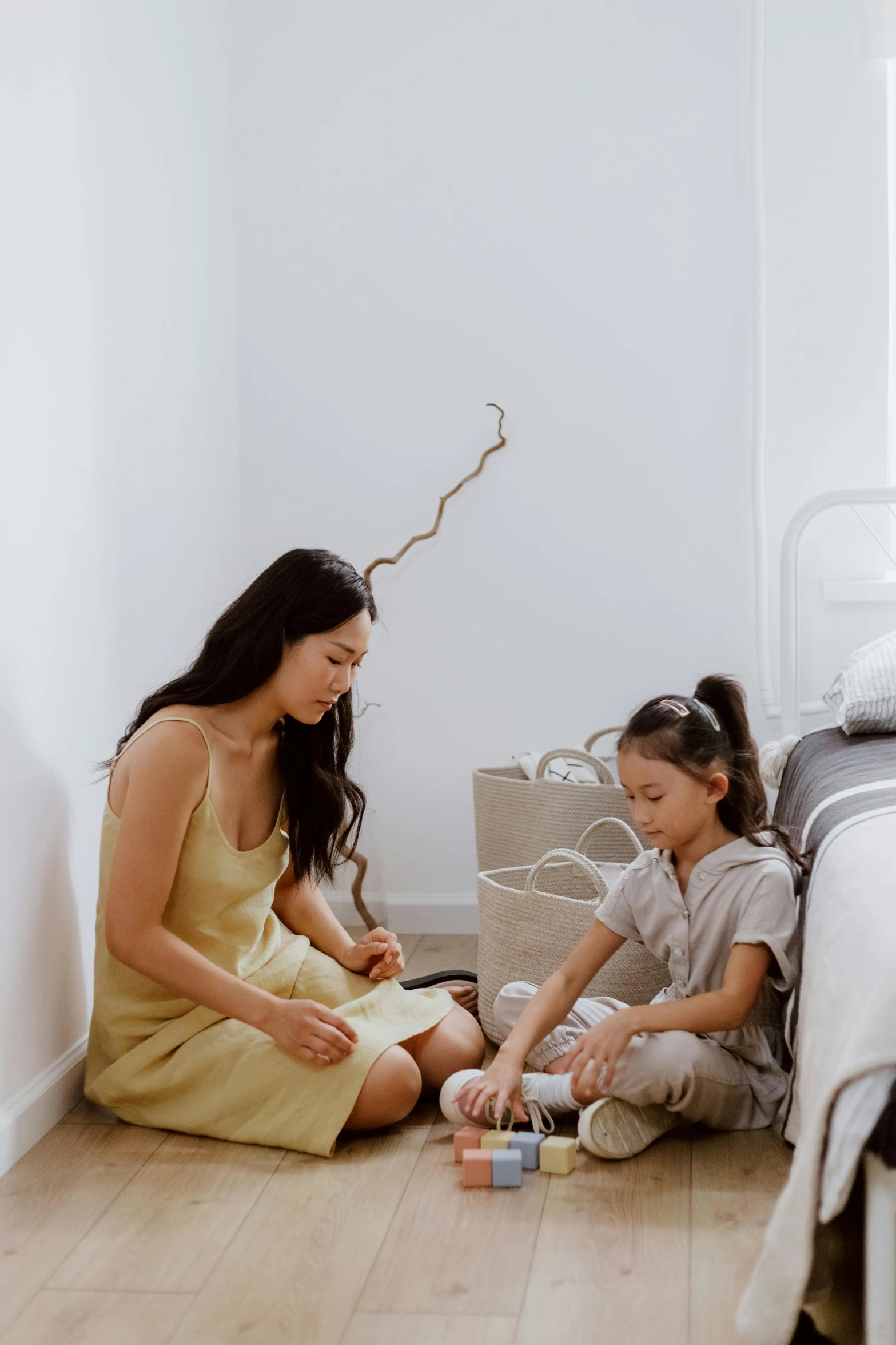 a woman sitting on the floor next to a little girl, wearing wheat yellow gauze, sitting in bedroom, katherine lam, linen