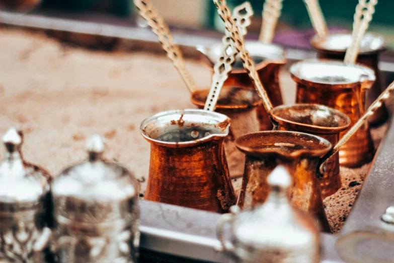 a tray that has some cups and spoons on it, a still life, trending on unsplash, hurufiyya, middle eastern details, ancient coffee machine, sparkling in the sunlight, thumbnail